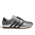 Bliss sneakers marka, metalik gümüş renkli, çatlak dokulu yüzeye sahip bağcıksız adidas Samba spor ayakkabı.