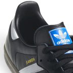 Bliss sneakers adidas Samba siyah deri spor ayakkabı, dil kısmında mavi logo ve yan tarafta altın Samba yazısı