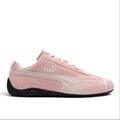 Bliss sneakers marka pembe süet Puma spor ayakkabı, yan kısımlarında kontrast detaylar ve siyah kauçuk taban ile.
